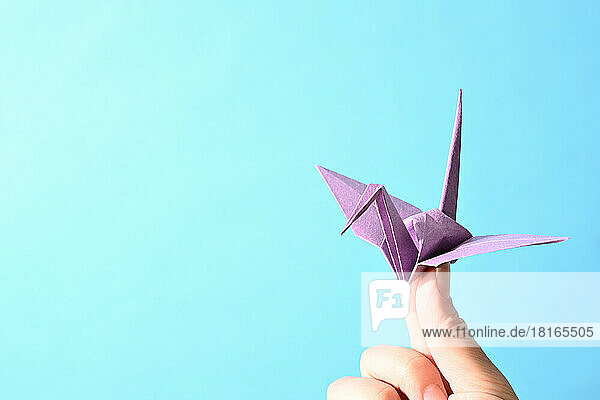Frau hält Origami-Papierkranich