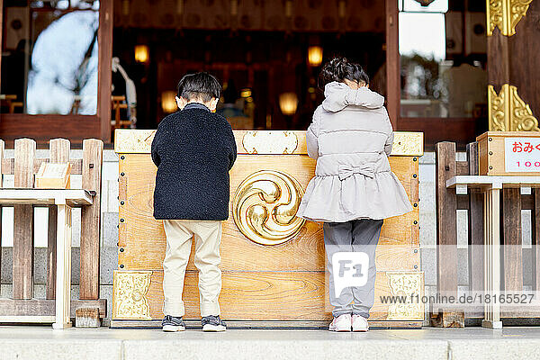 Japanische Kinder beim Beten im Tempel
