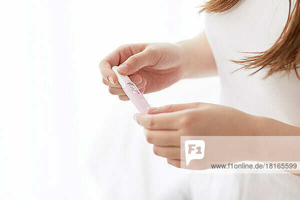 Japanerin mit Schwangerschaftstest