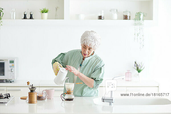 Japanische Seniorin brüht Kaffee