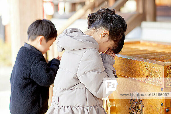 Japanische Kinder beim Beten im Tempel