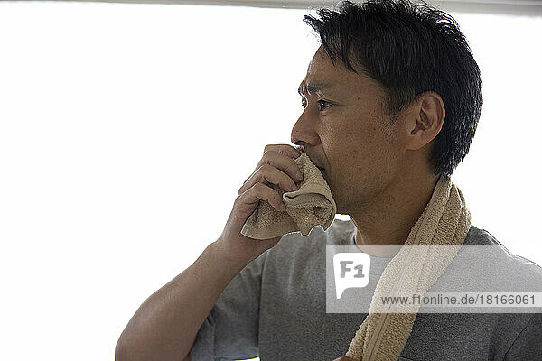 Japanese man wiping his mouth with a towel