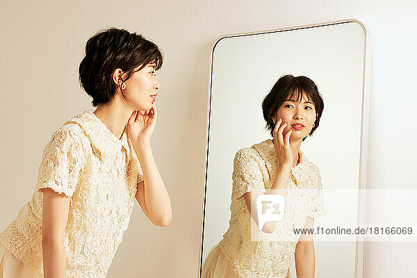 Young Japanese woman looking in the mirror