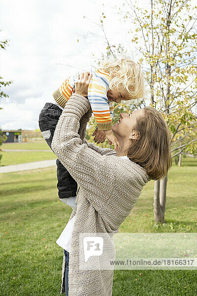 Happy woman playing with son at park