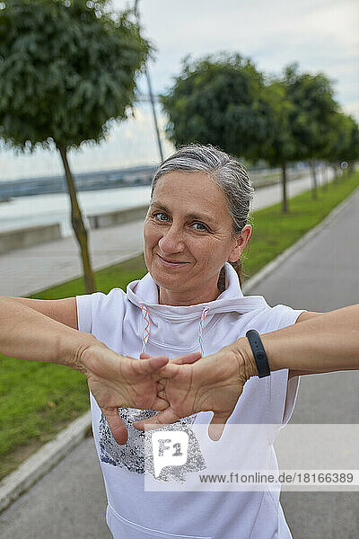 Smiling mature woman stretching fingers