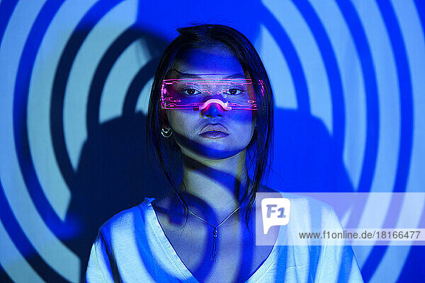 Spiral shadow on young woman wearing LED futuristic glasses