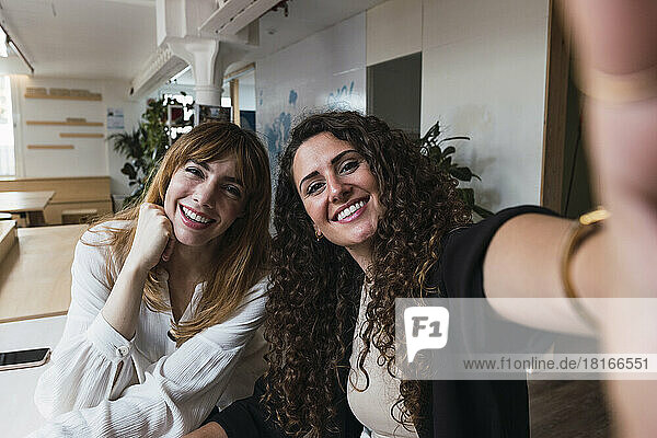 Zwei glückliche Geschäftsfrauen machen ein Selfie im Büro