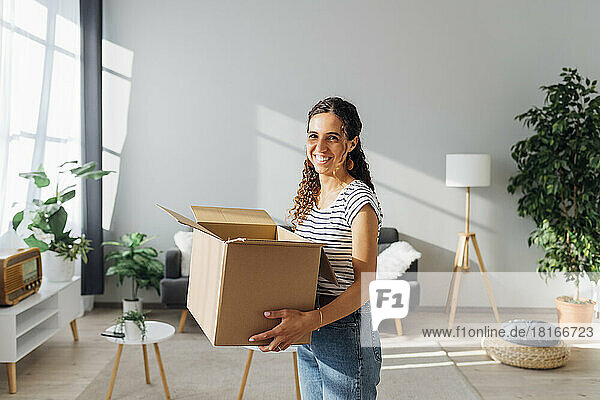 Happy woman with box relocating in new home