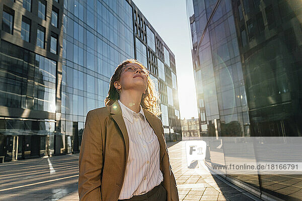 Thoughtful businesswoman looking up on sunny day