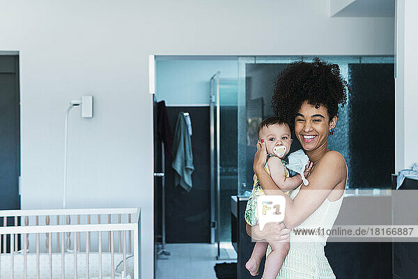 Cheerful woman with baby boy at home