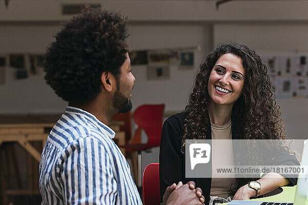 Smiling businesswoman looking at colleague in office