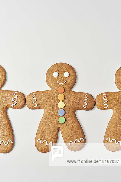 Freshly decorated gingerbread men lying on white background