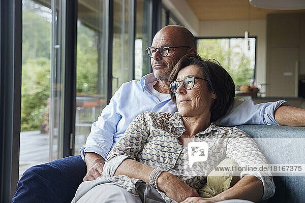 Liebevolles Seniorenpaar verbringt zu Hause Zeit miteinander auf dem Sofa