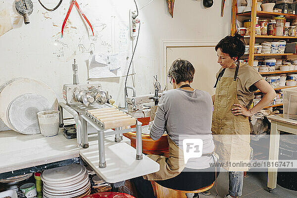 Entrepreneur with colleague working in ceramics workshop
