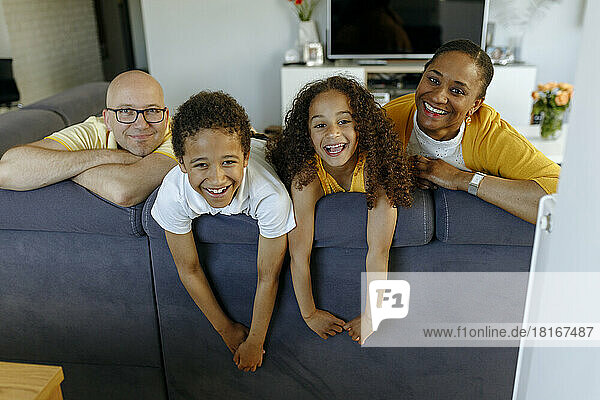 Happy children with parents on sofa at home