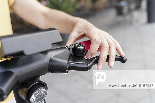 Hand of woman on electric push scooter brake