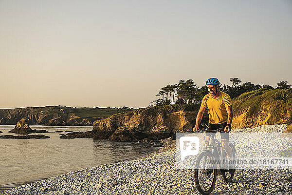 Reifer Mann hat Spaß beim Fahrradfahren am Strand