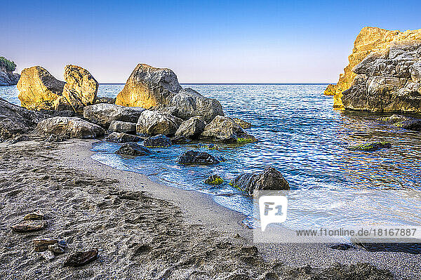 Idyllic view of rocks in sea at beach