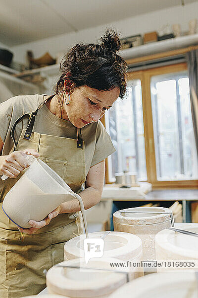 Töpfer gießt in der Werkstatt Ton in Keramik