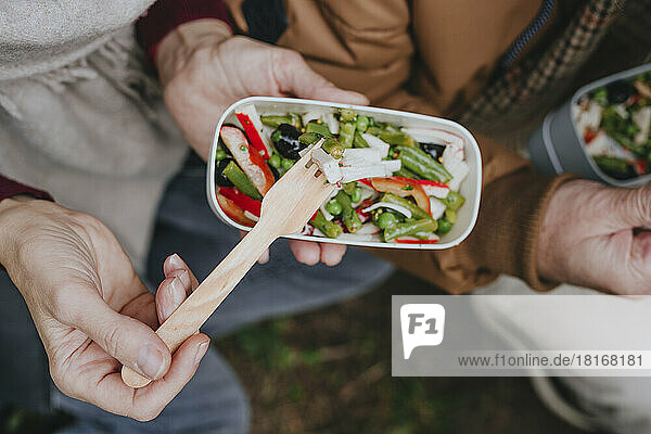 Reife Frau isst Salat mit Mann