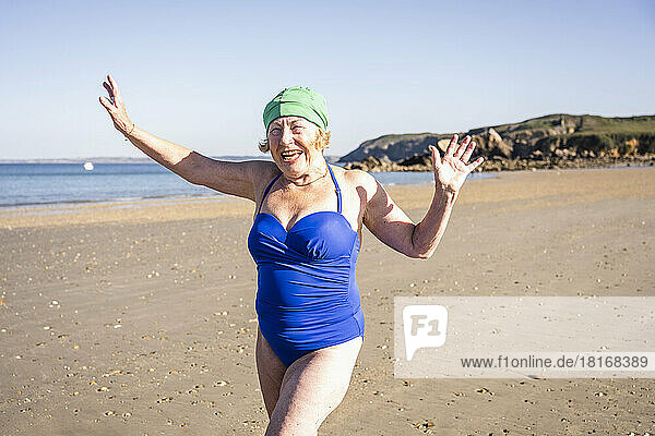 Verspielte ältere Frau genießt den Strand