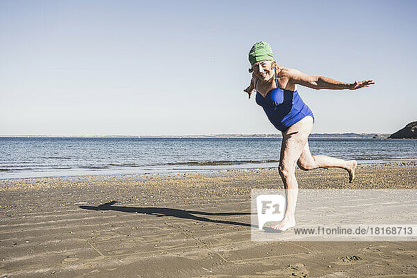Frau hat Spaß beim Laufen am Strand an einem sonnigen Tag