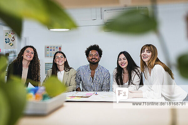 Portrait of happy business team at table in office