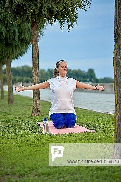 Mature woman doing stretching exercise at park