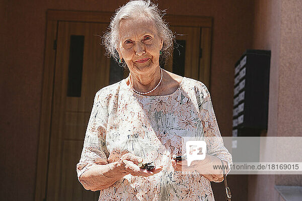 Senior woman with car keys on sunny day