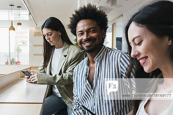Portrait of smiling businessman with female colleagues in office