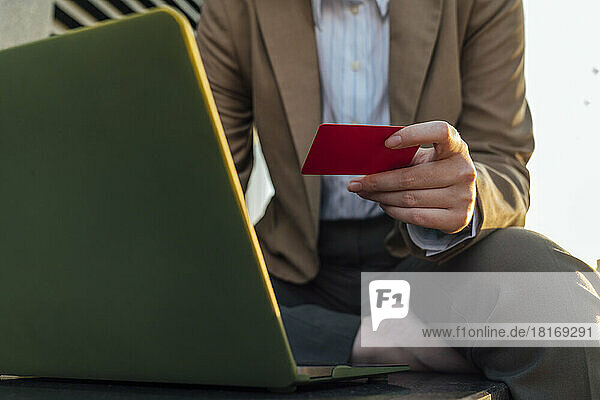 Geschäftsfrau benutzt Laptop und bezahlt mit Kreditkarte