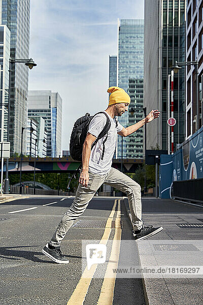 Man wearing knit hat walking on road in city