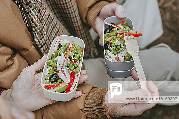 Couple with healthy salad in lunch box