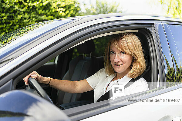 Smiling mature woman driving car