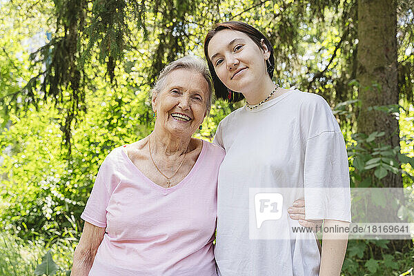 Glückliche Seniorin mit Enkelin steht im Park