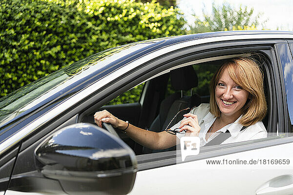 Happy mature woman sitting in car