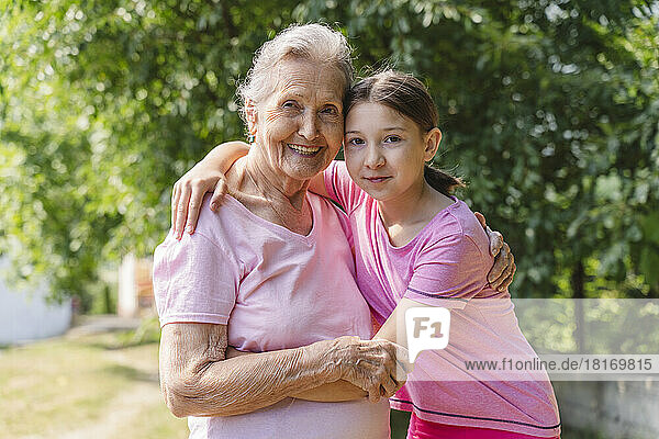 Glückliche Seniorin umarmt Enkelin im Park