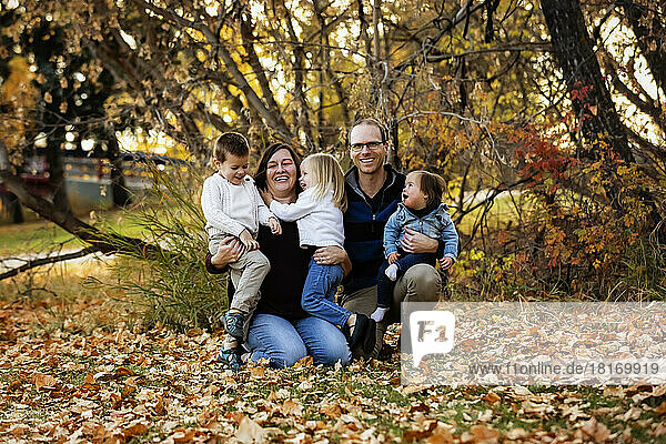 Porträt einer jungen Familie mit drei Kindern  die jüngste Tochter mit Down-Syndrom  in einem Stadtpark während der Herbstsaison; St. Albert  Alberta  Kanada