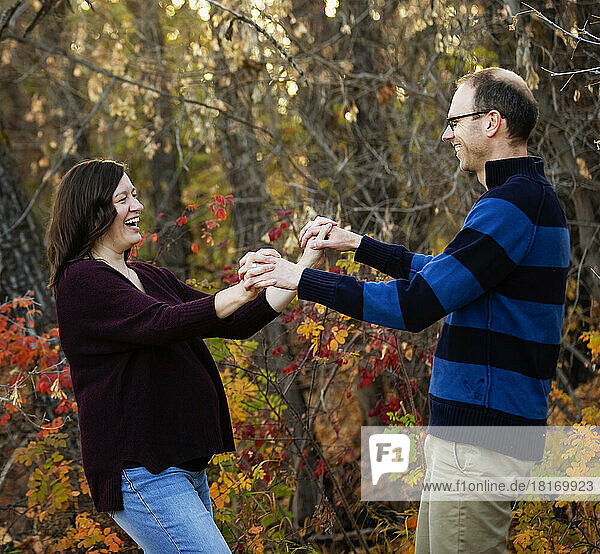 Mature married couple spending quality time together and dancing together outdoors in a city park during the fall season; St. Albert  Alberta  Canada