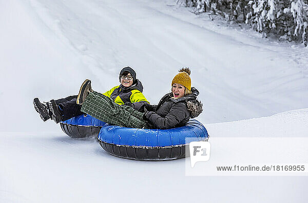 Mutter und Sohn beim Tubing auf einem Skihügel; Fairmont Hot Springs  British Columbia  Kanada