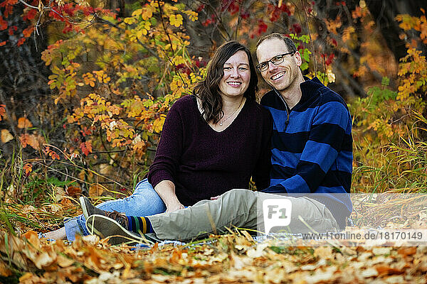 Porträt eines reifen Ehepaars  das während der Herbstsaison in einem Stadtpark Zeit miteinander verbringt; St. Albert  Alberta  Kanada