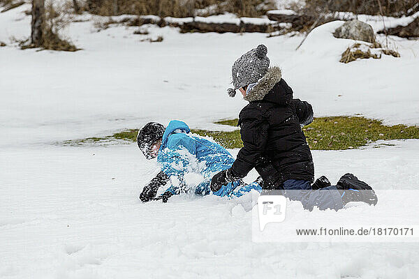 Zwei Jungen spielen im Schnee in einem Bergdorf; Fairmont Hot Springs  British Columbia  Kanada