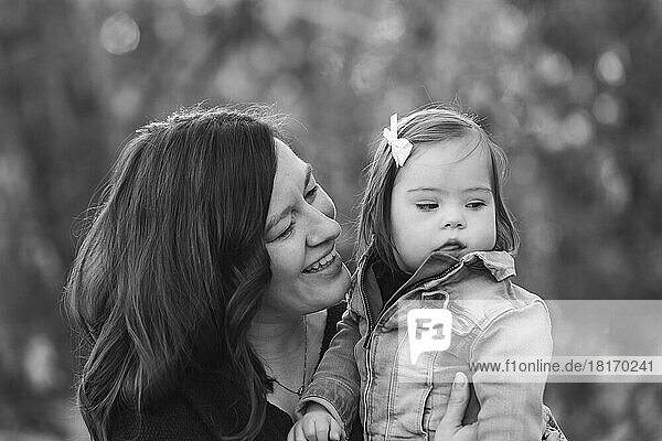 Porträt einer Mutter und ihres kleinen Mädchens mit Down-Syndrom  die während eines Familienausflugs in einem Stadtpark viel Zeit im Freien verbringen; St. Albert  Alberta  Kanada