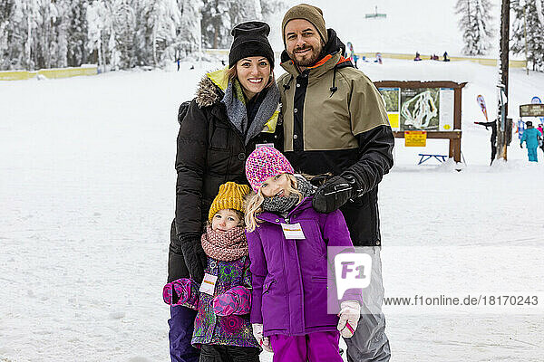 Parents and their children posing for a picture while vacationing at a ski resort; Fairmont Hot Springs  British Columbia  Canada