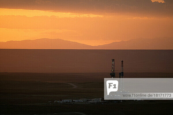 Erdgasbohrinseln in der Landschaft von Wyoming vor einem orange leuchtenden Himmel bei Sonnenuntergang; Pinedale  Wyoming  Vereinigte Staaten von Amerika