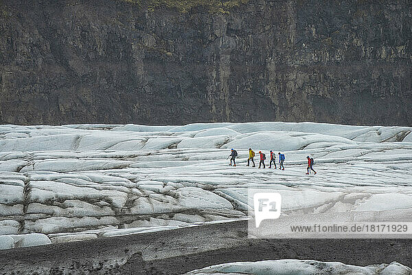 Gruppe von Menschen  die auf einem Gletscher an der Südküste Islands spazieren gehen; Südküste  Island
