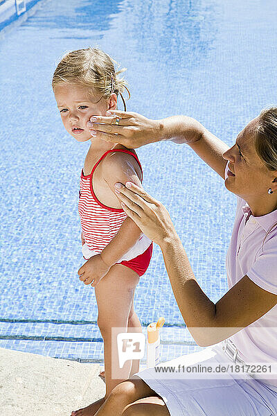 Mother Applying Sunscreen on Daughter's Face