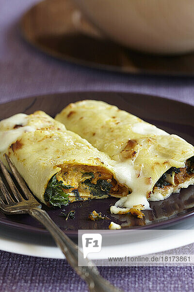 Baked cannelloni with squash and leafy greens topped with cheese