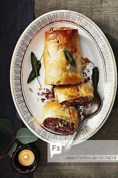 Vegetable strudel on a platter with candle