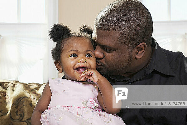 Portrait of Father Kissing Baby Girl on Cheek